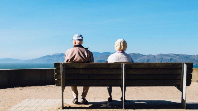 Aging couple on bench overlooking mountains